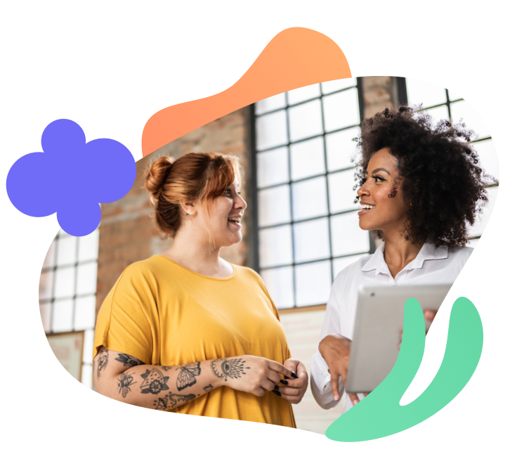 Two young business women having a conversation holding an iPad