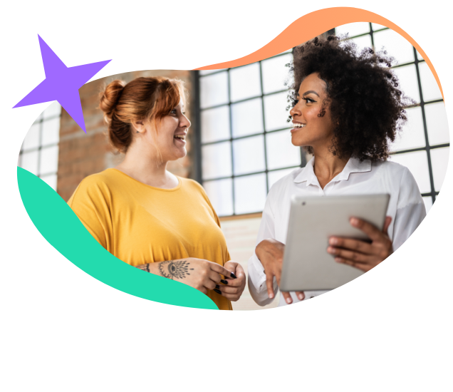 Two young business women having a conversation holding an iPad