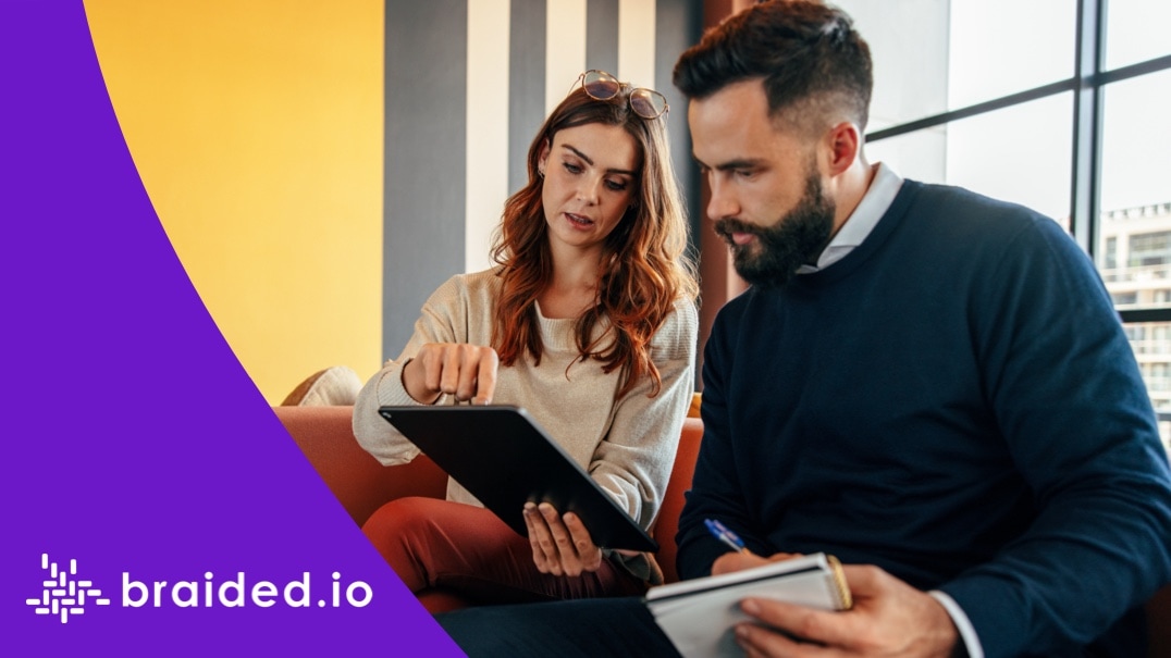 Focused businesspeople having a discussion in a lobby and Braided.io logo